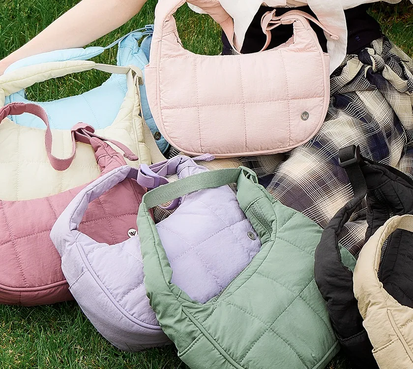 Quilted shoulder bags in six colourways laid out on grass